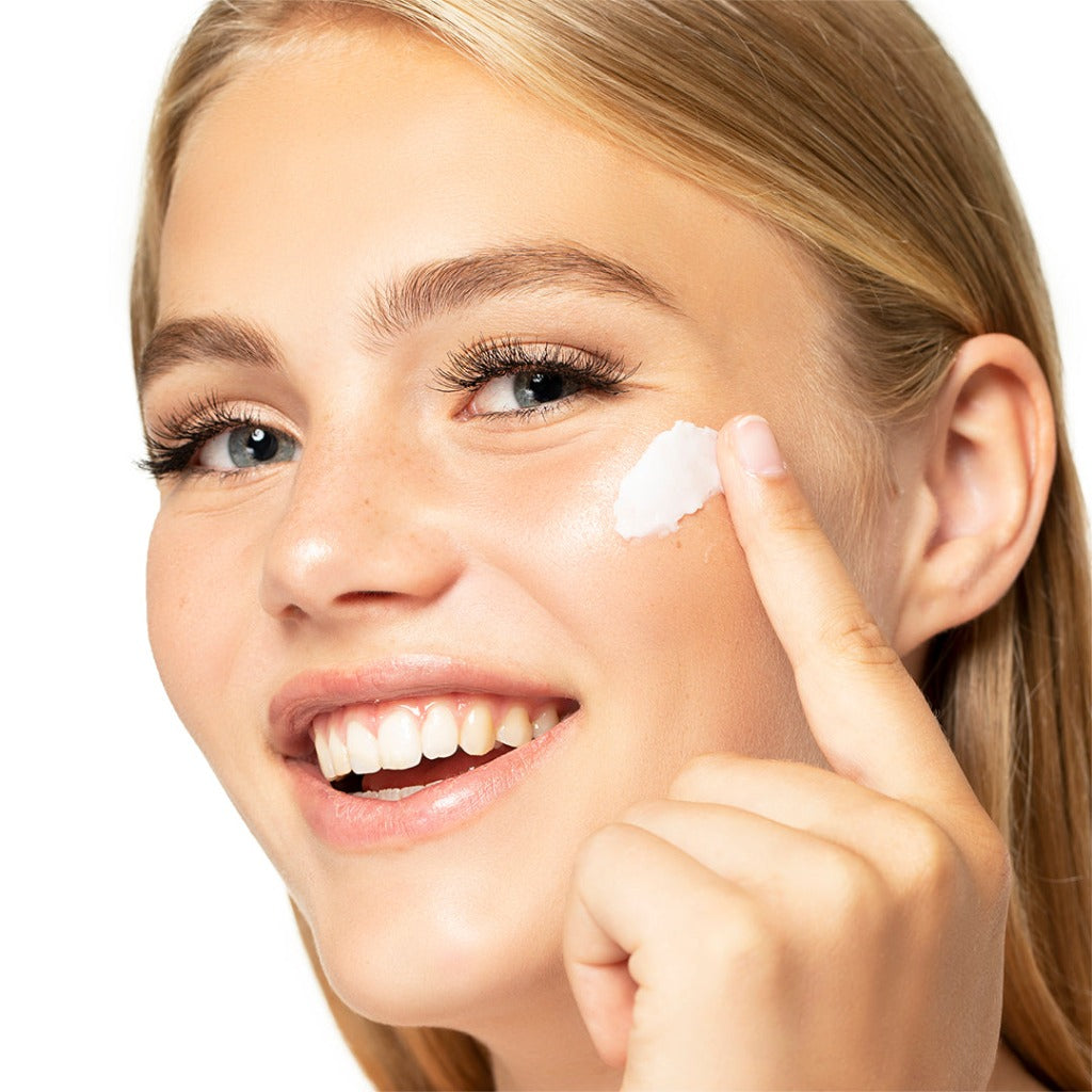 Image of a model who is applying the STARSKIN ORGLAMIC Pink Cactus Pudding cream on her cheek