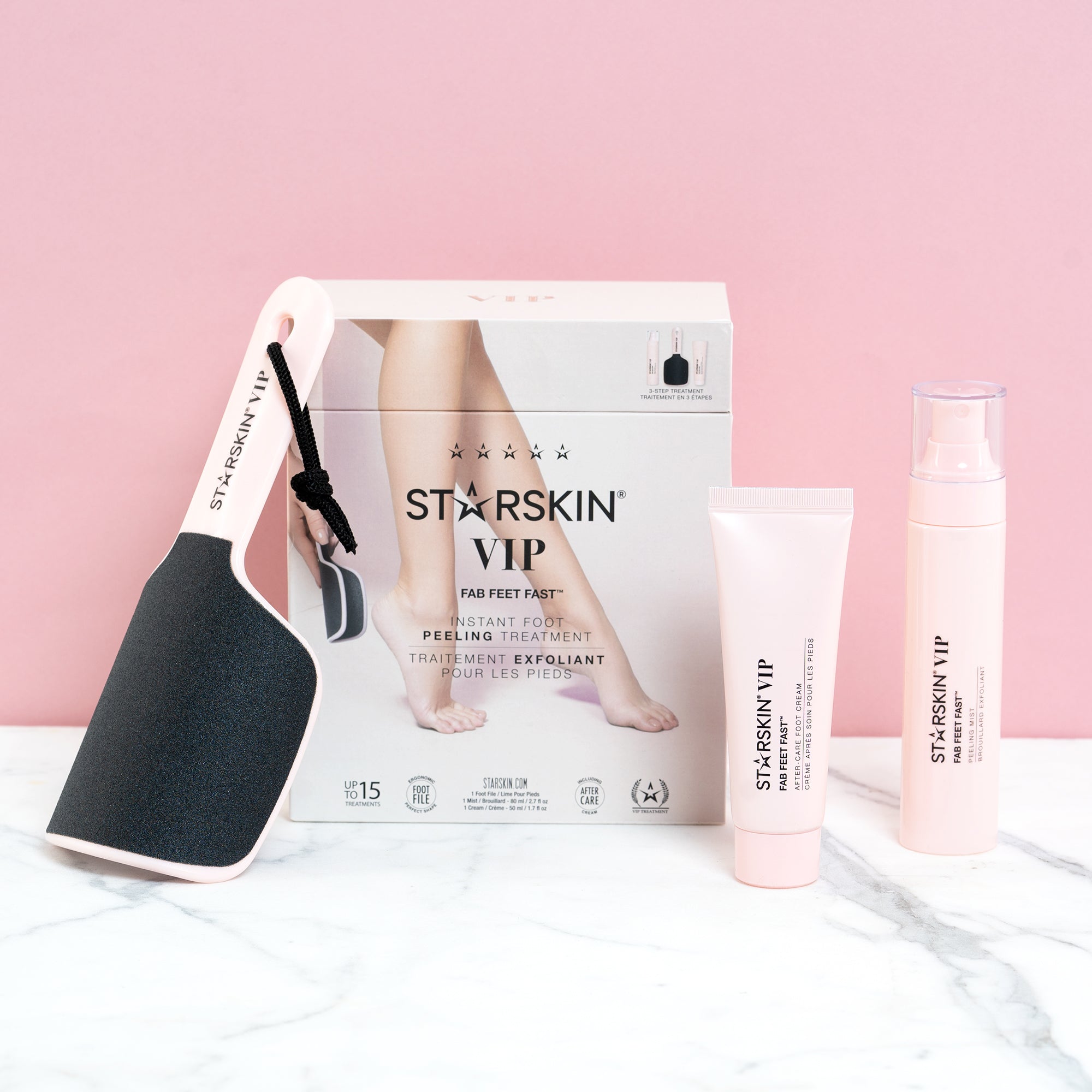 All the products inside the starskin fab fast set being displayed on a marble table with a pink background. The products are leaning on the product packaging box