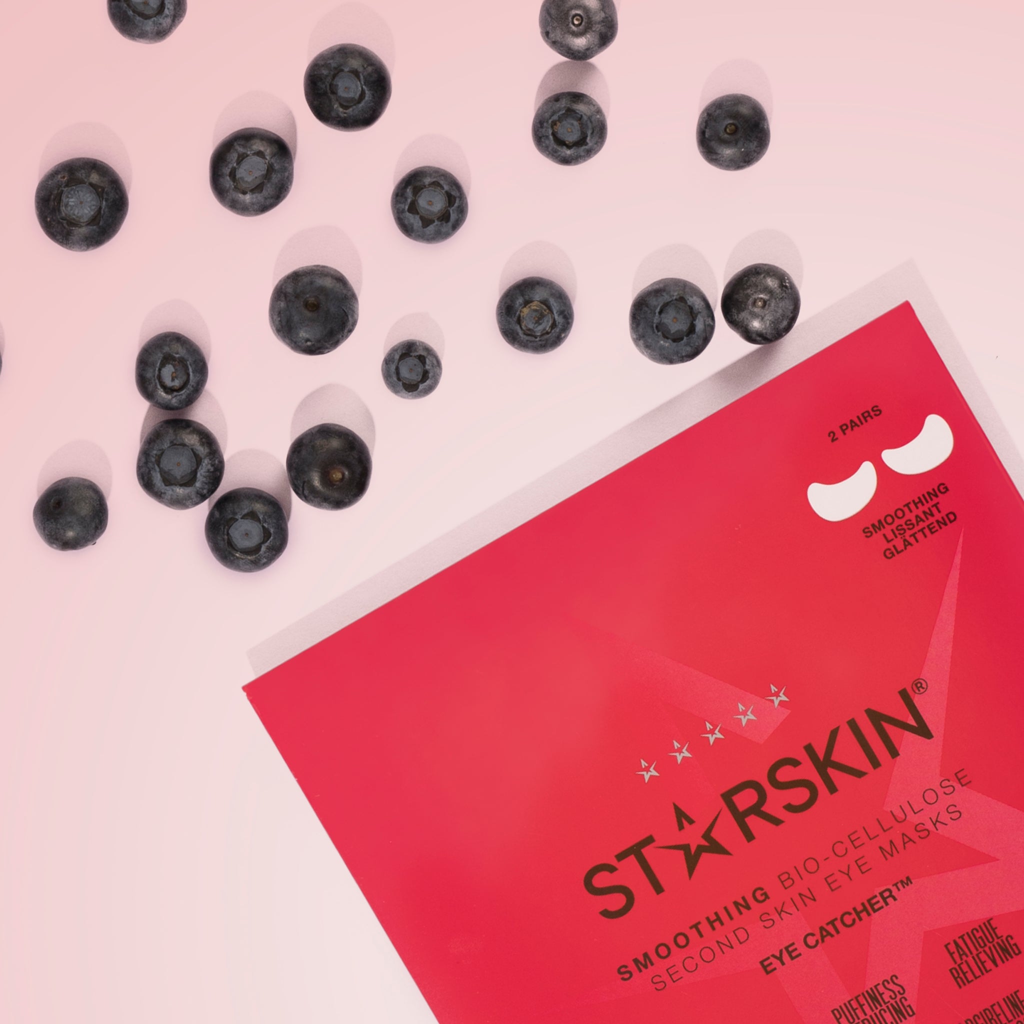 Starskin's eye catcher on the bottom right and blueberries in the top left corner. On a light pink background. 