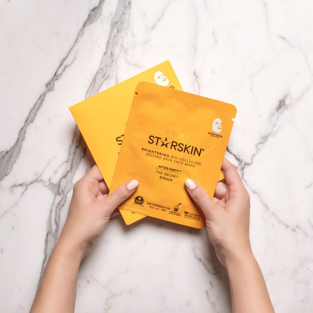 A marble background where two hands show the envelope and sachet of the STARSKIN After Party mask