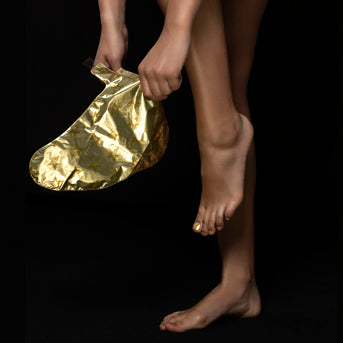 Model puts on Starskin VIP The Gold Foot mask
