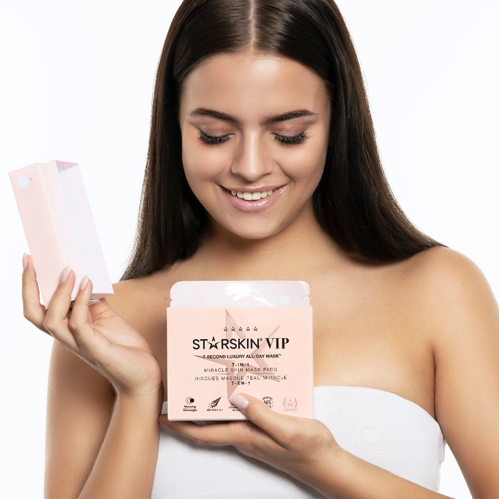 Model opening the box of the STARSKIN VIP 7-Second Luxury All Day Mask 18 pack