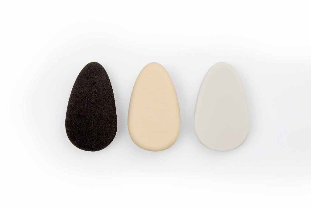 An image showing the different puffs and stone available for the STARSKIN Artist FX. On the left is the black Artist FX Rubycell puff, next to it is the nude colored Artist FX Silicone puff and on the right is the white Artist FX Ceramic stone