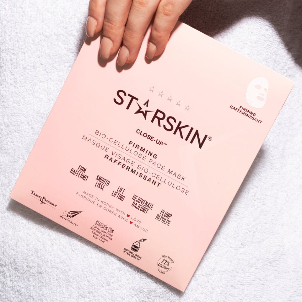 Atmospheric image of a hand holding the STARSKIN Close-up face sheet mask