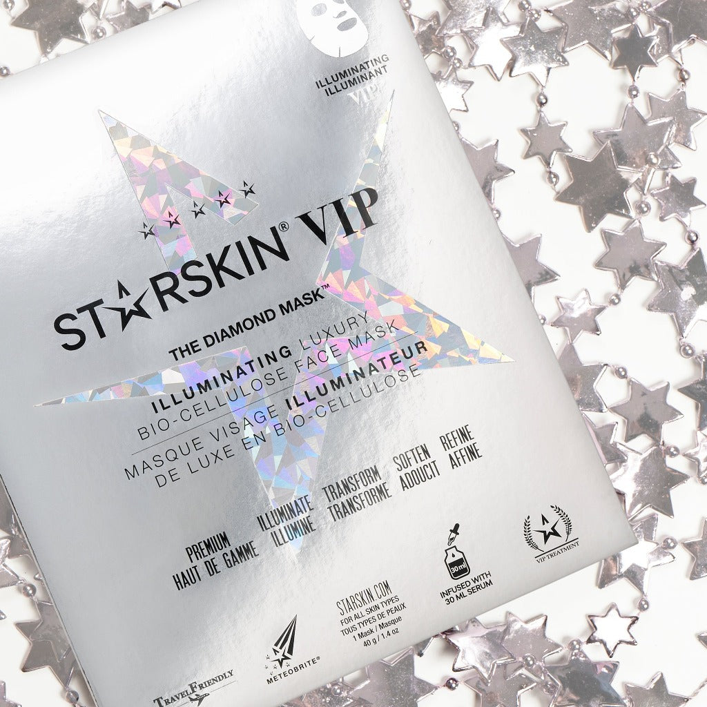 Atmospheric image of Starskin VIP The Diamond Gold Mask with silver sparkly stars in the back
