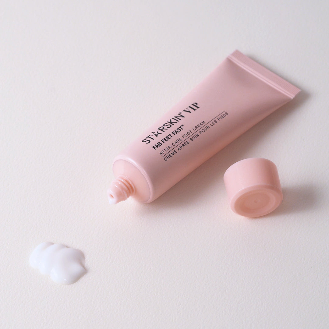 The fab after care foot cream tube is laying on a white background. The tube is opened and a small drop of the product is in front of the product. 