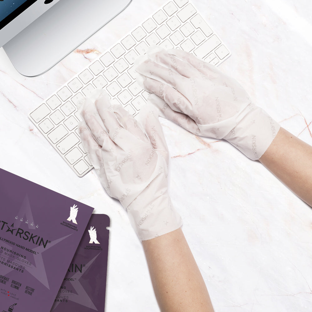 Atmospheric image of two hands wearing the STARSKIN Hollywood Hand Model mask and typing on a computer keyboard with the package laying next to the keyboard